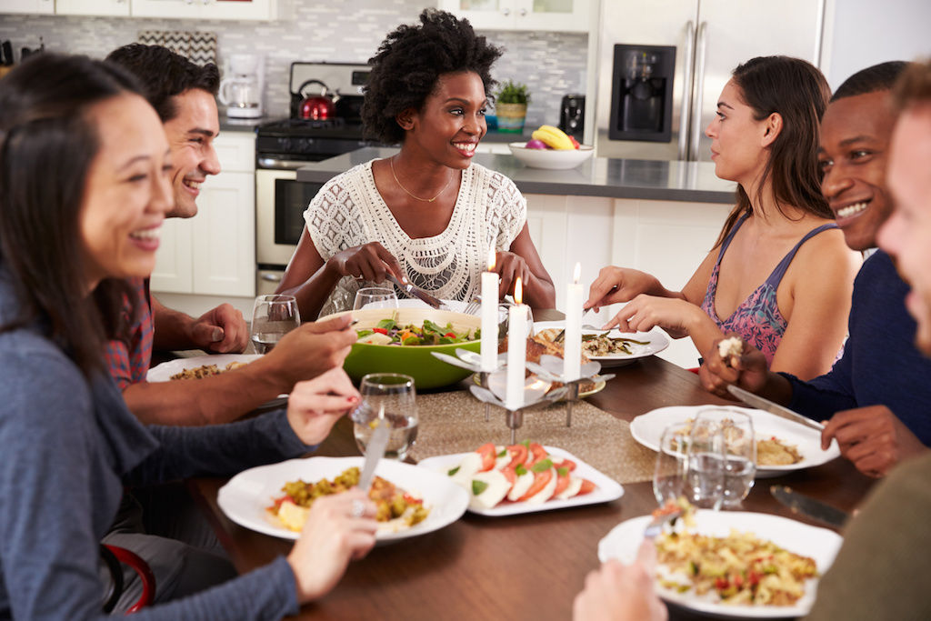 Friends gathering around table at dinner party
